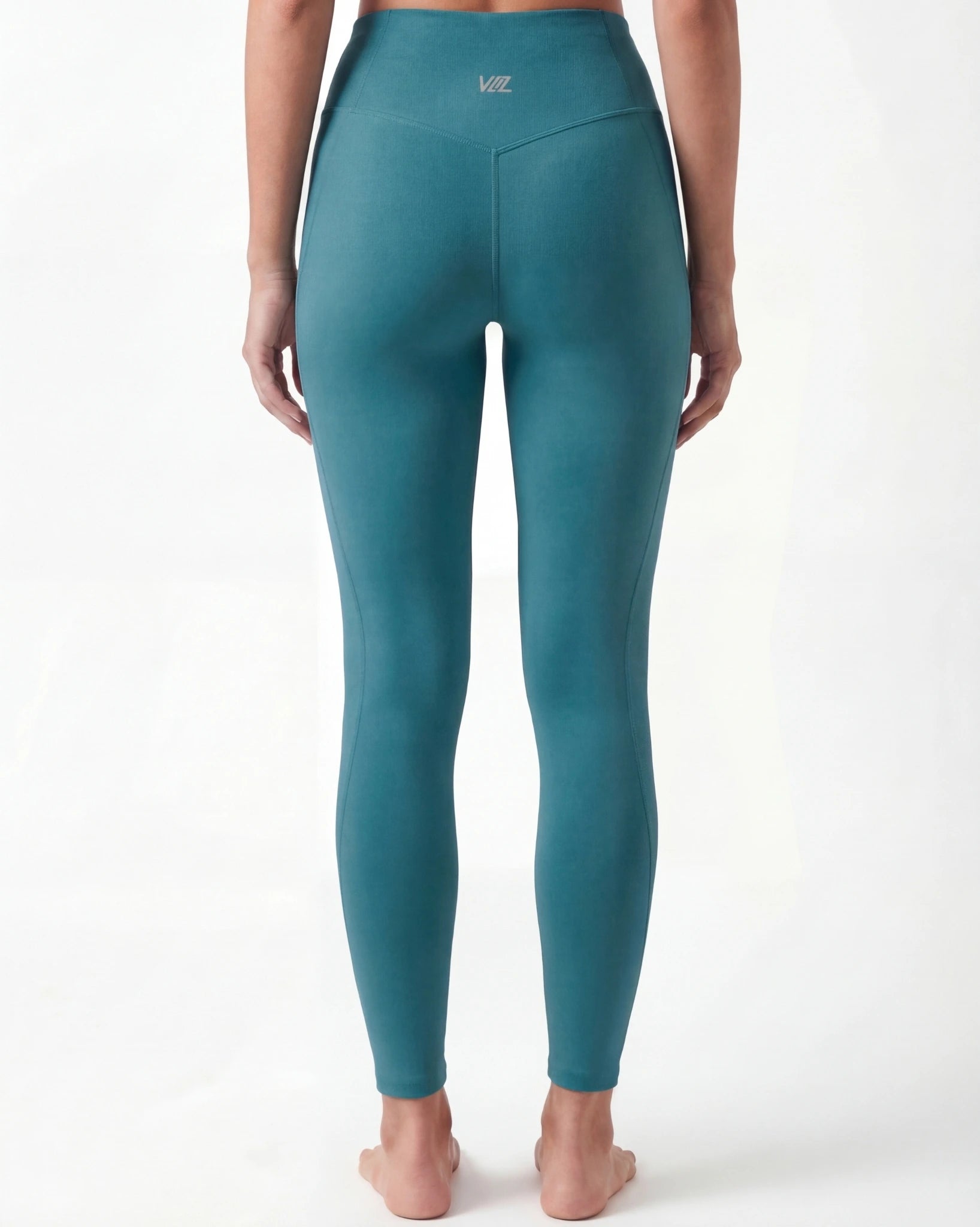Teal leggings worn by a person on a white background
