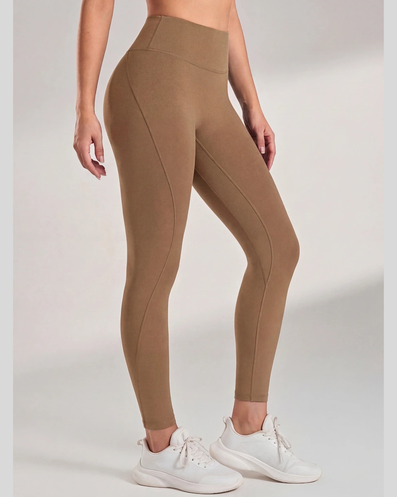 Brown leggings worn by a person on a white background