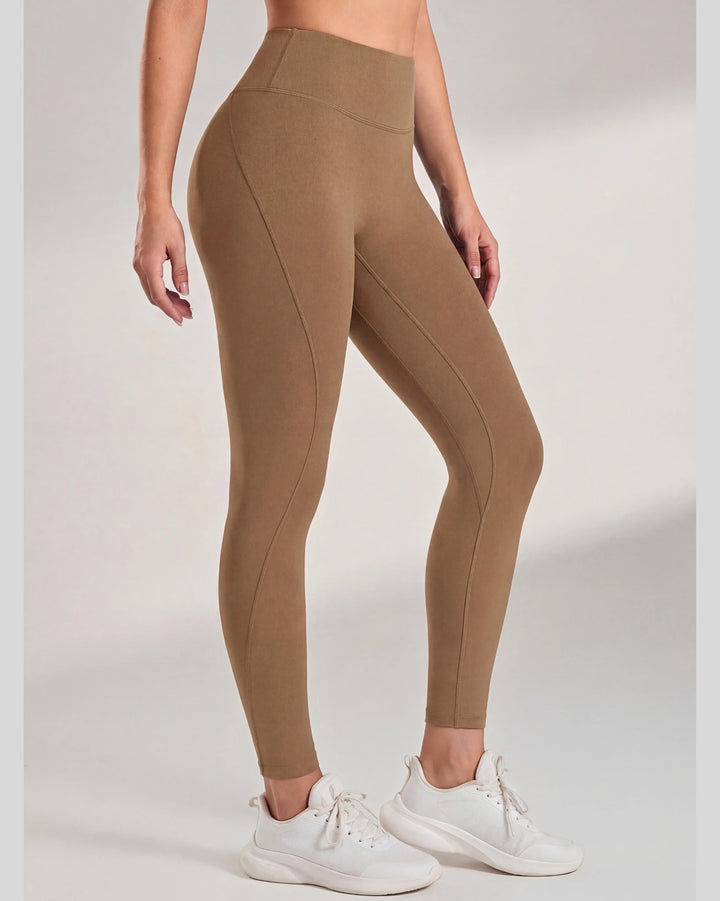 Brown leggings worn by a person on a white background
