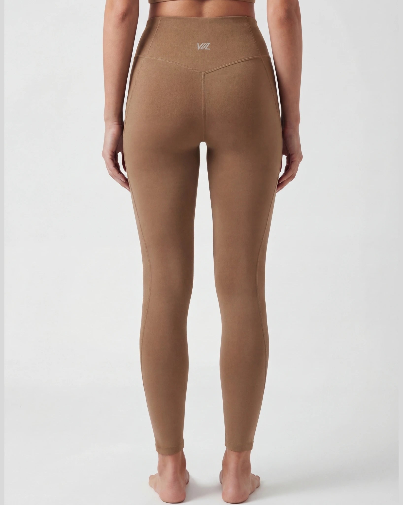 Brown leggings worn by a person on a white background
