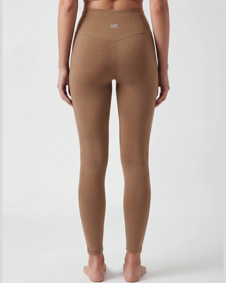Brown leggings worn by a person on a white background