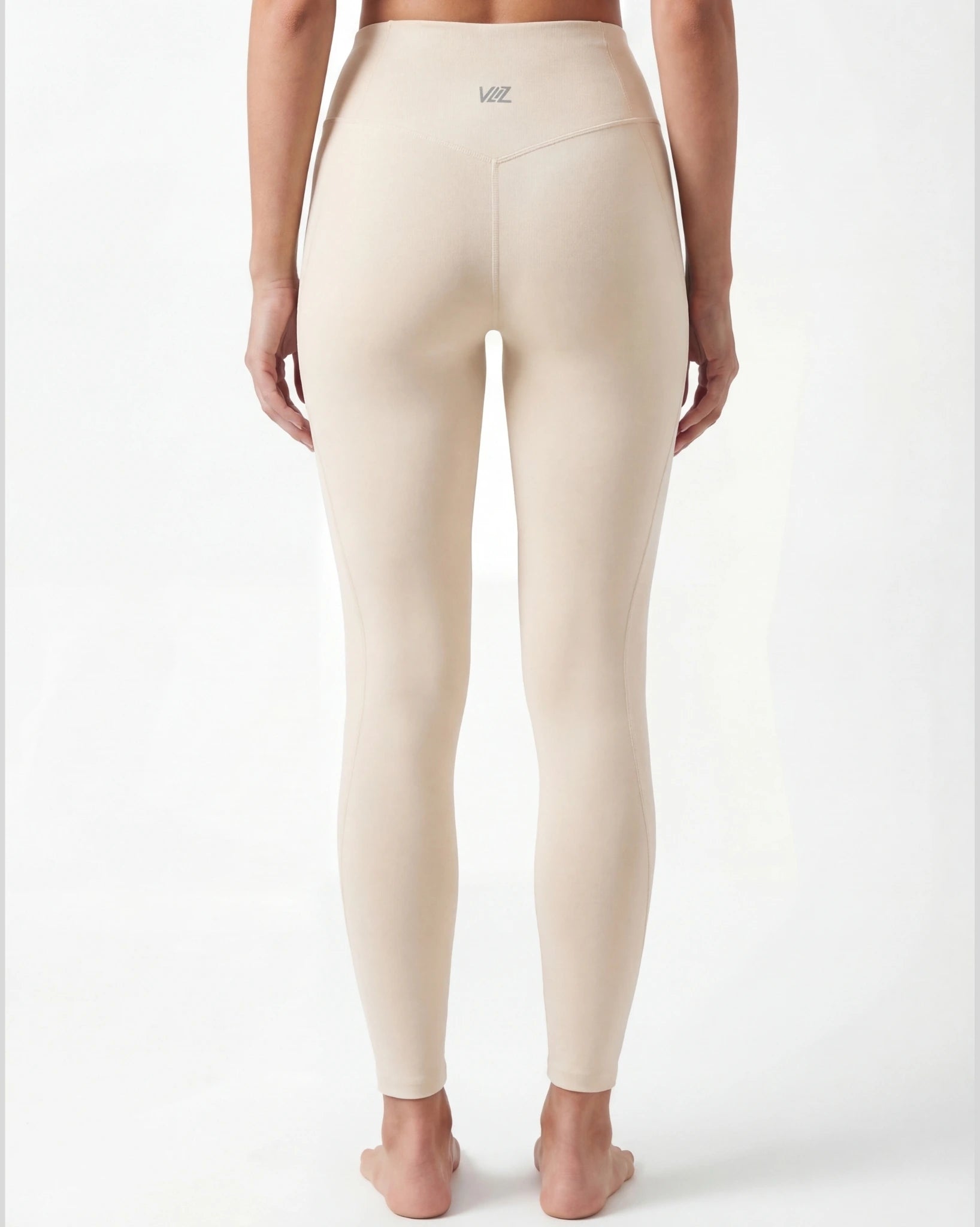 Beige leggings worn by a person on a white background