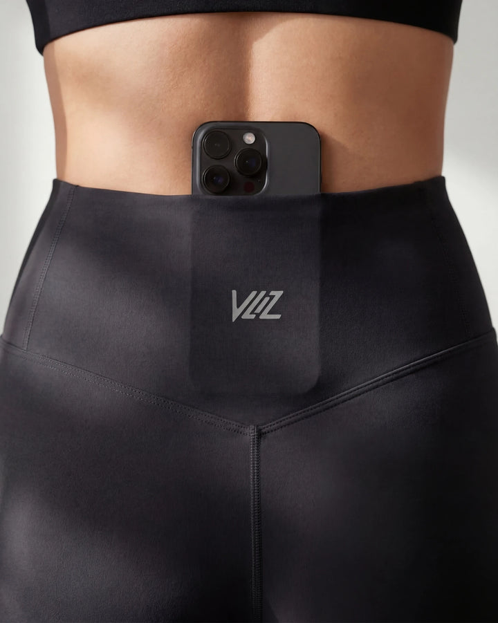 Person wearing black leggings with a phone case featuring 'YIZ' branding.