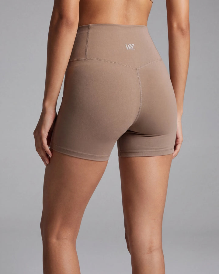 Brown high-waisted shorts with a logo on a gray background
