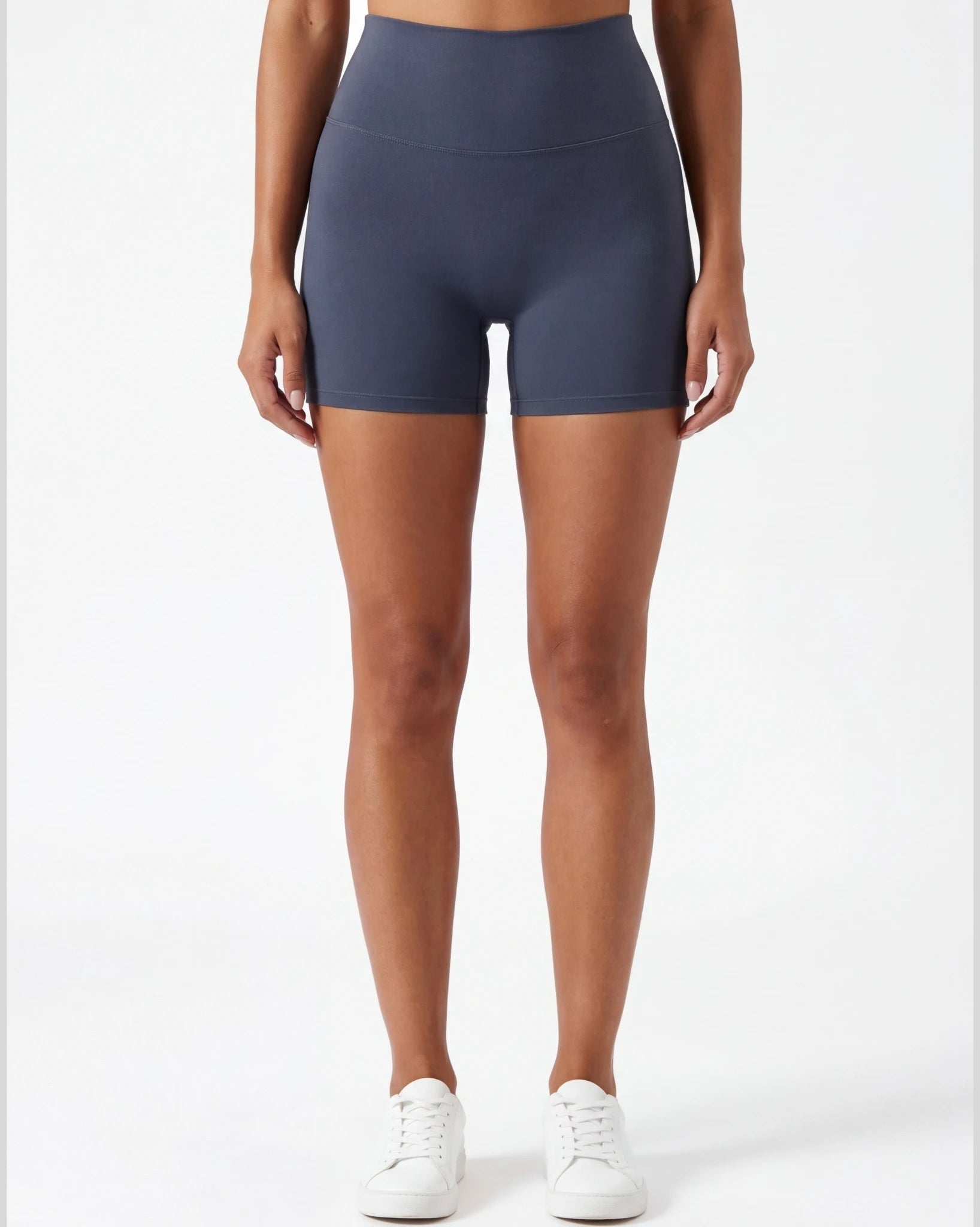 Person wearing navy blue athletic shorts on a white background