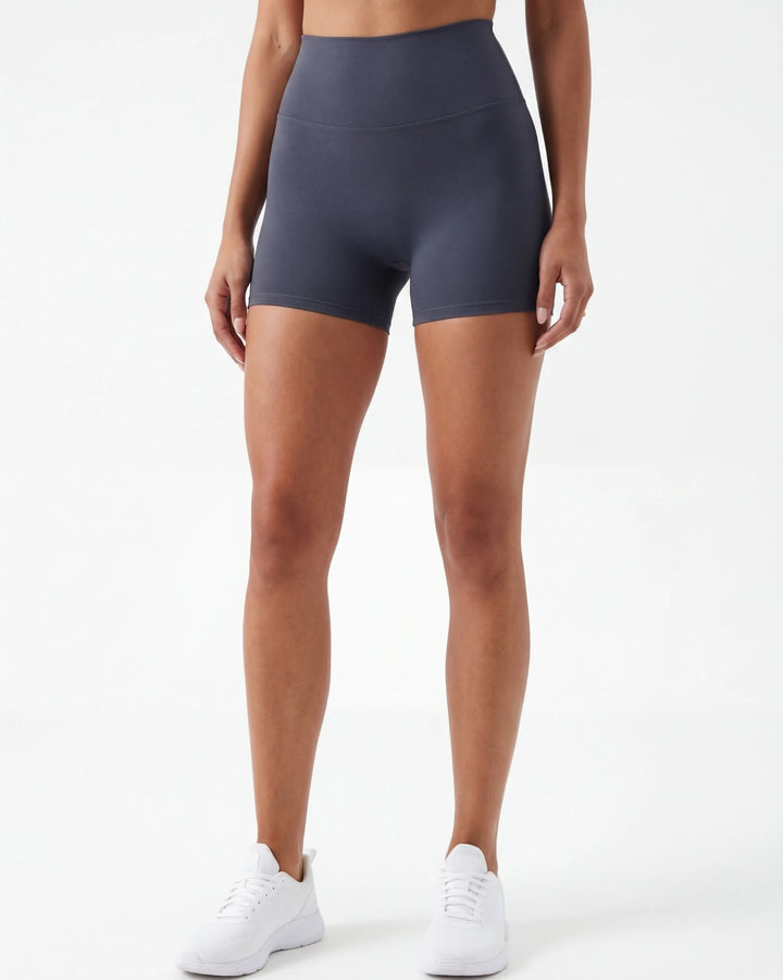 Person wearing dark gray high-waisted shorts on a white background