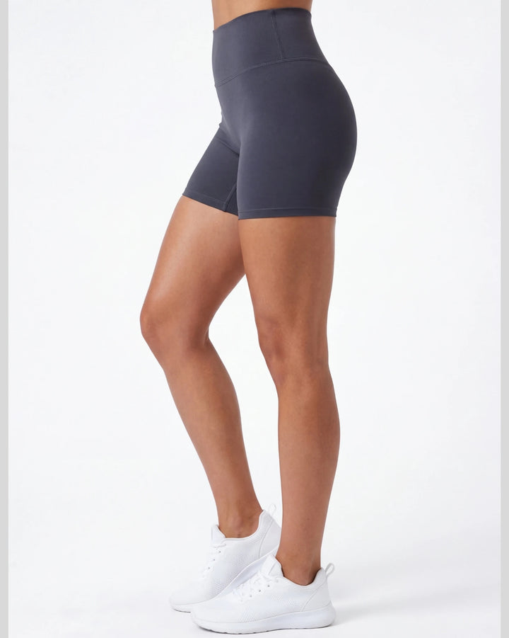 Person wearing dark gray high-waisted shorts on a white background