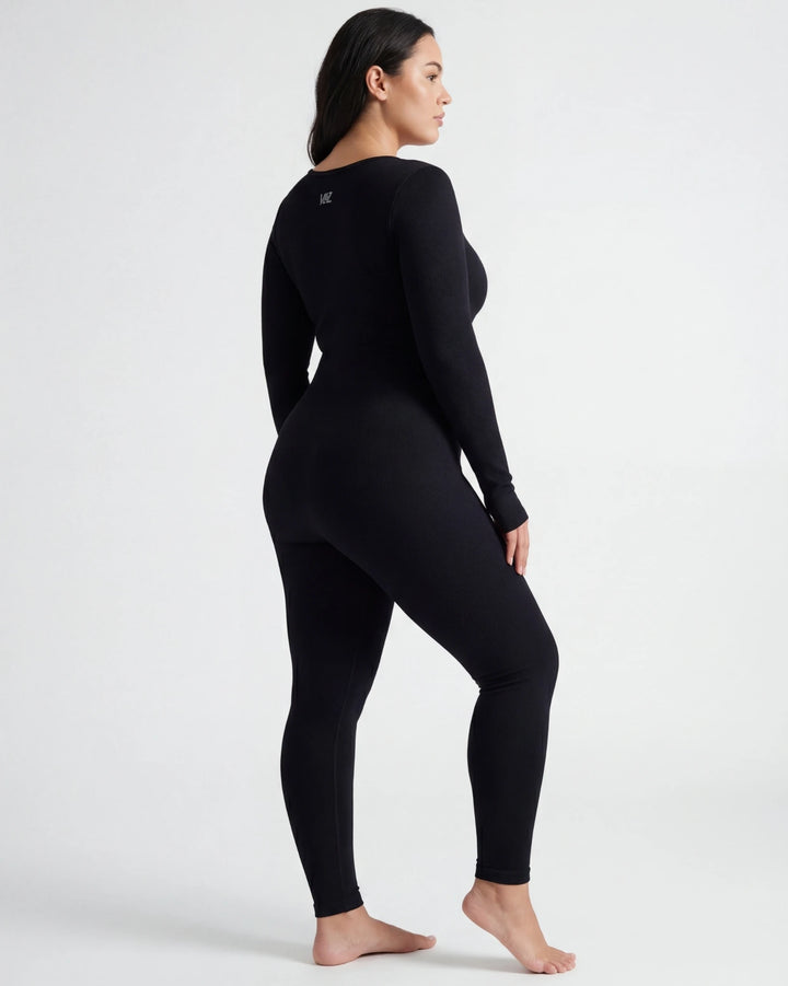 Person wearing a black long-sleeve top and leggings on a white background