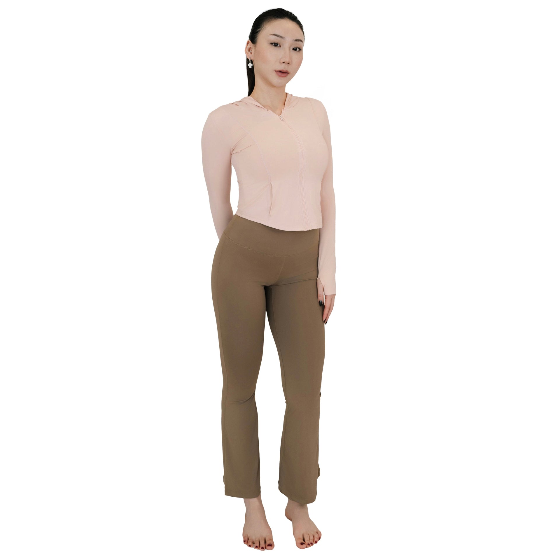 Model standing in VLIZ High-Rise Sculpting Flare Leggings in light brown, full-body front view paired with a light pink zip-up top.