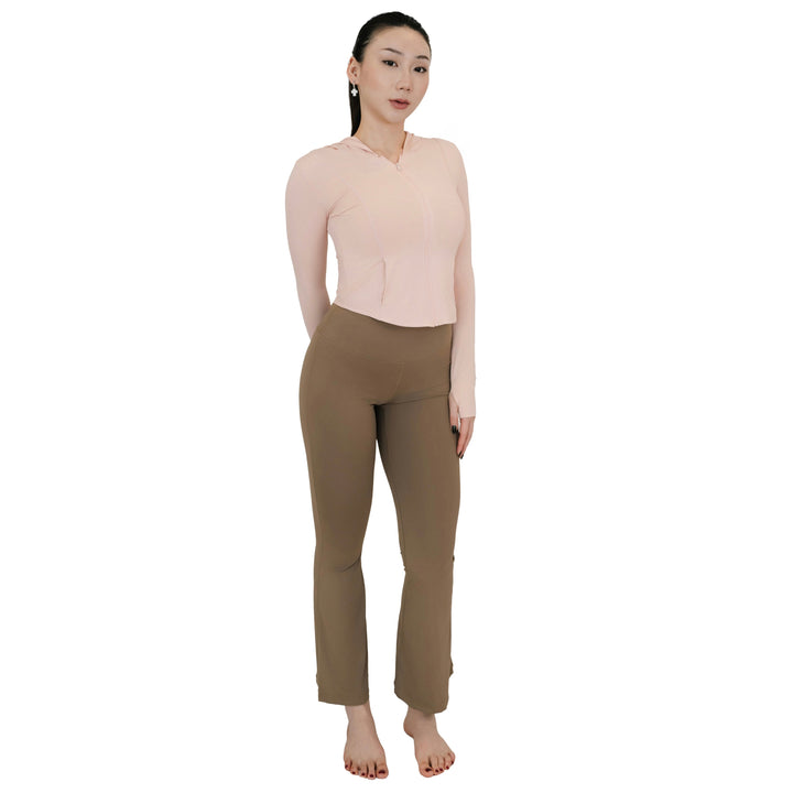 Model standing in VLIZ High-Rise Sculpting Flare Leggings in light brown, full-body front view paired with a light pink zip-up top.