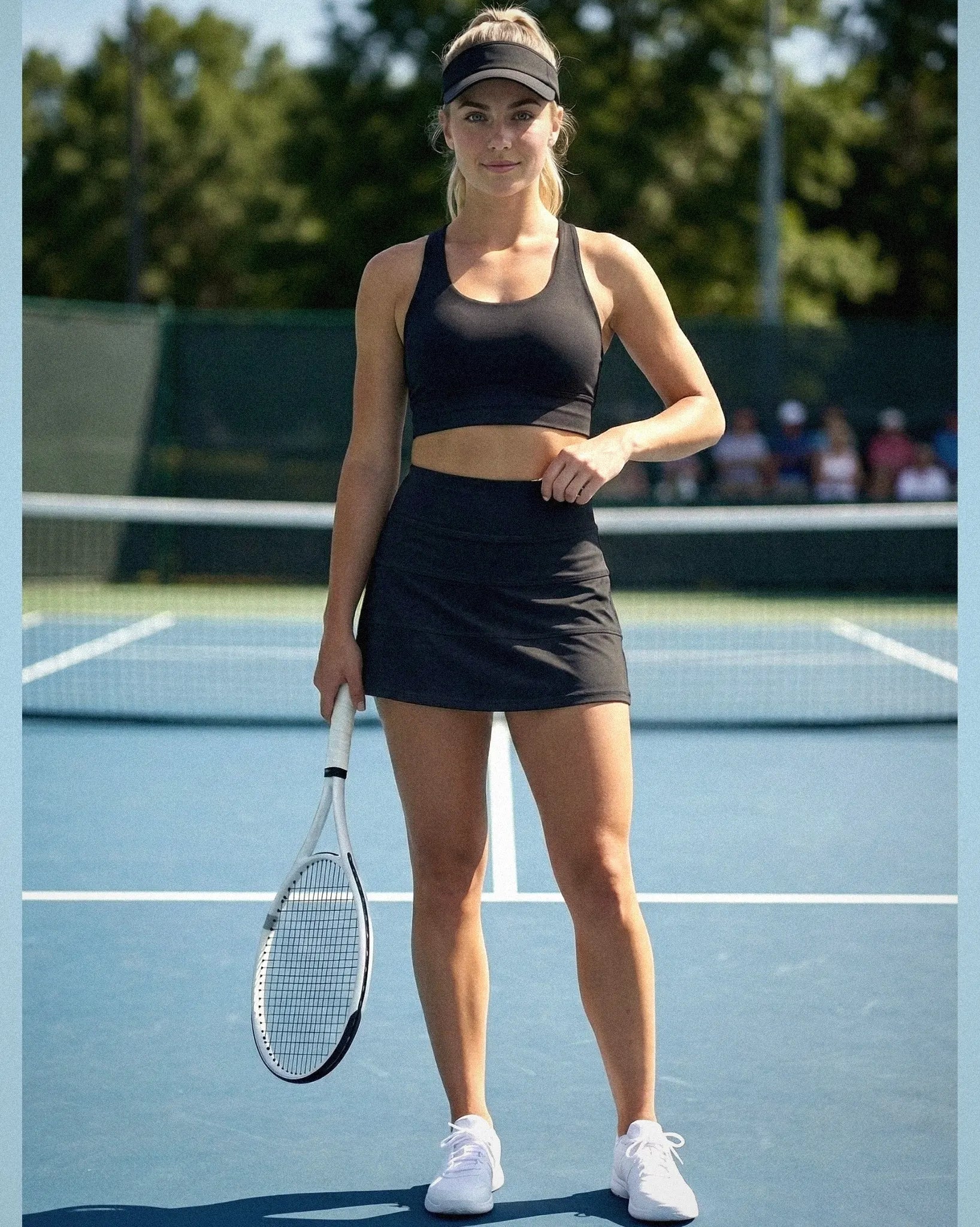 Woman in black athletic wear holding a tennis racket on a tennis court