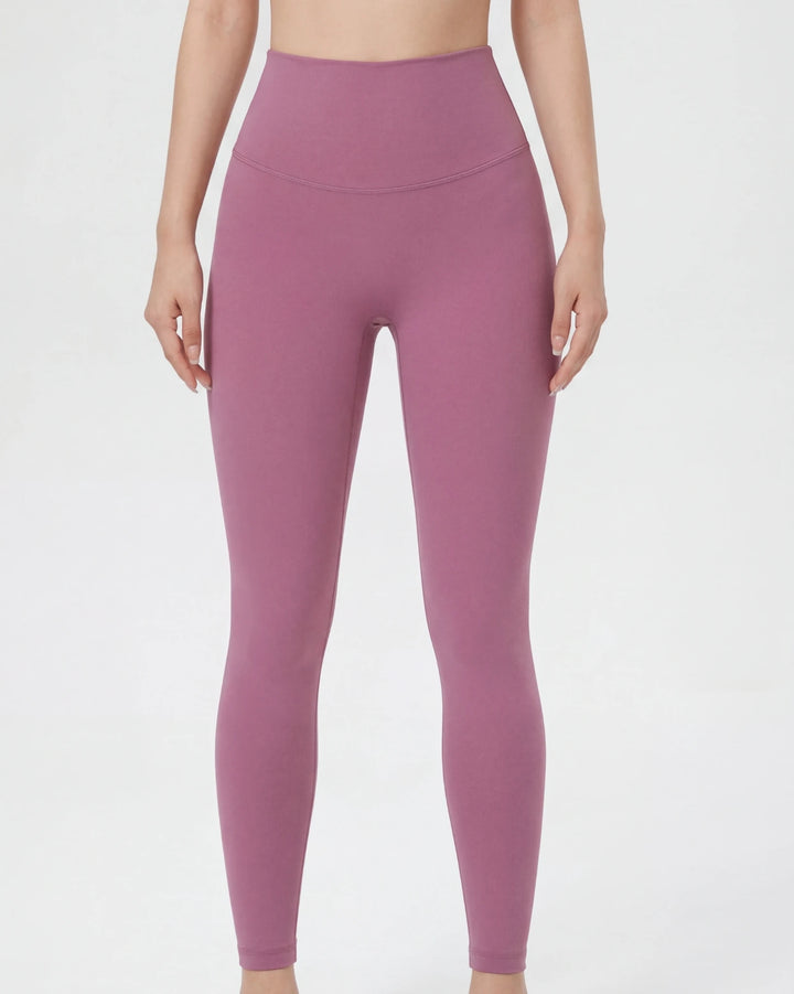 Person wearing a pair of pink leggings on a white background