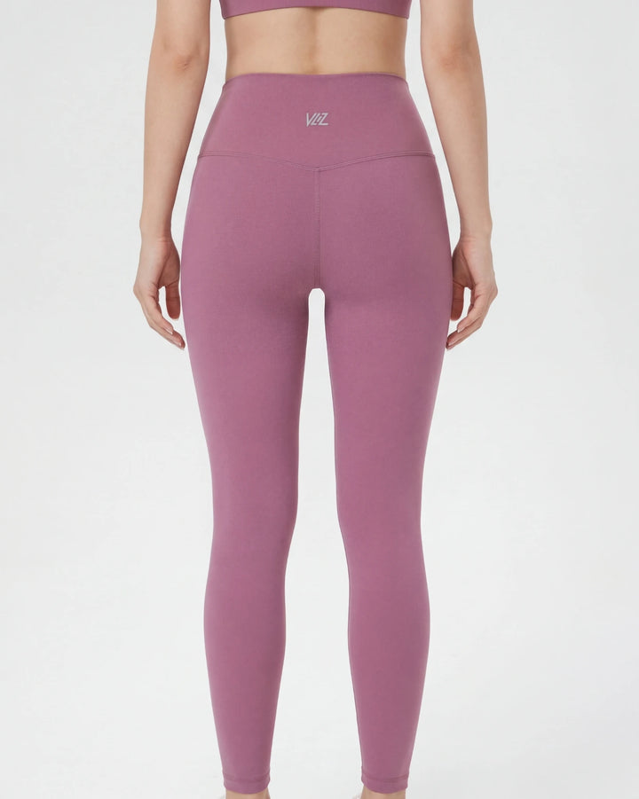 Person wearing pink leggings with a logo on a white background