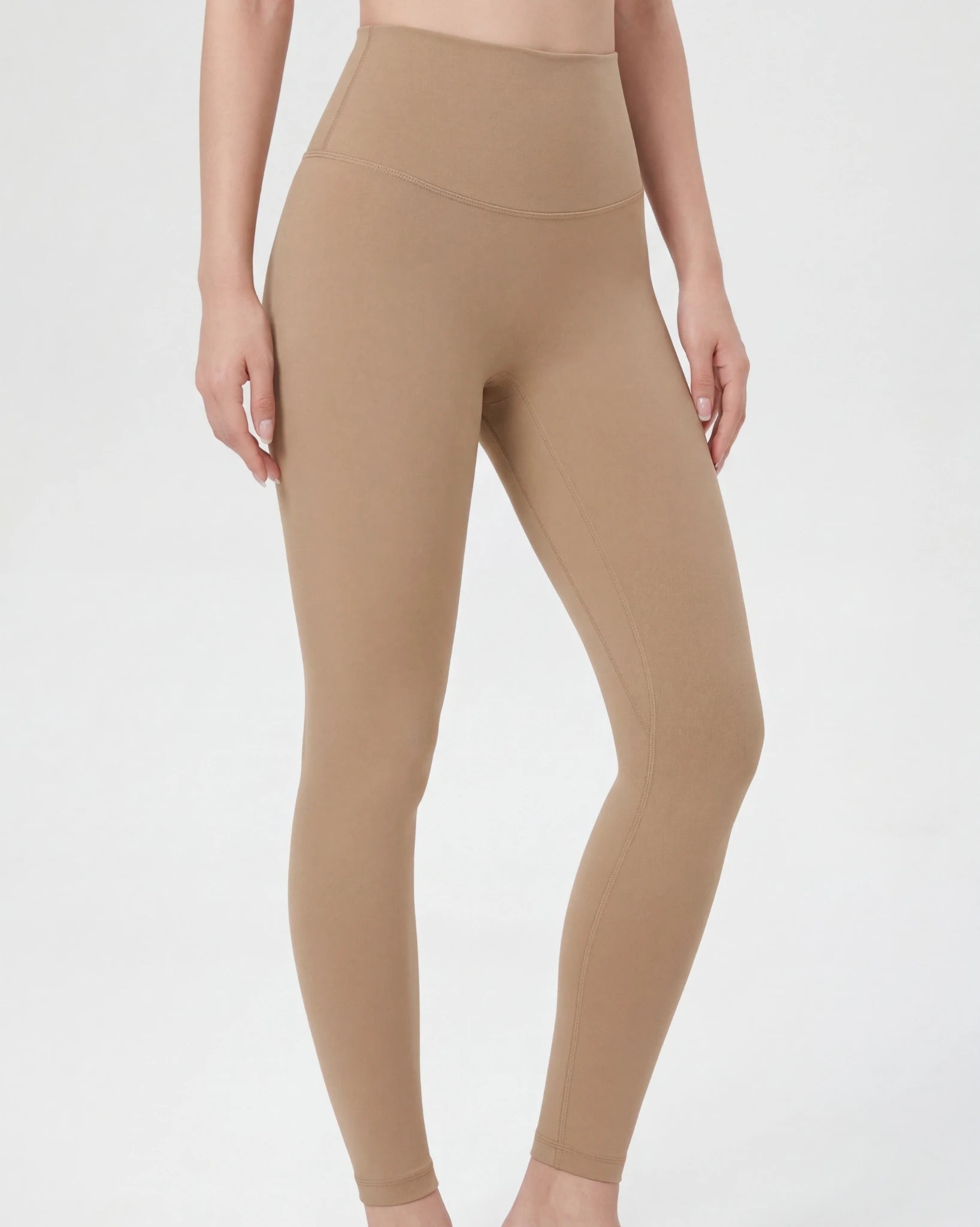 Beige leggings worn by a person on a light gray background