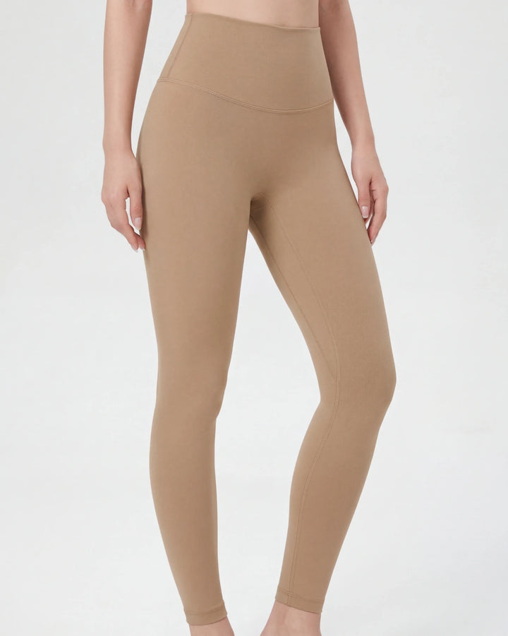Beige leggings worn by a person on a light gray background