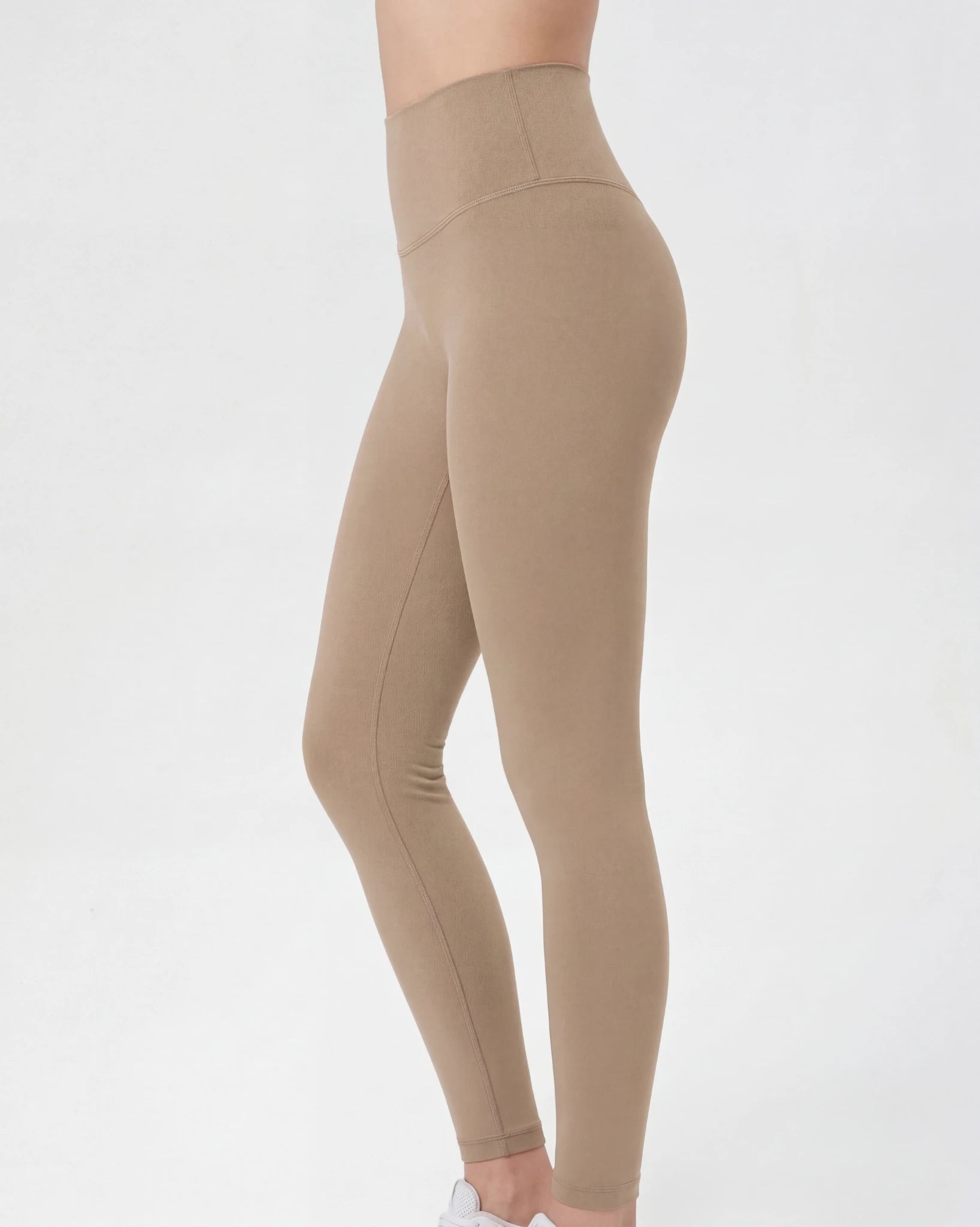 Beige leggings worn by a person on a white background