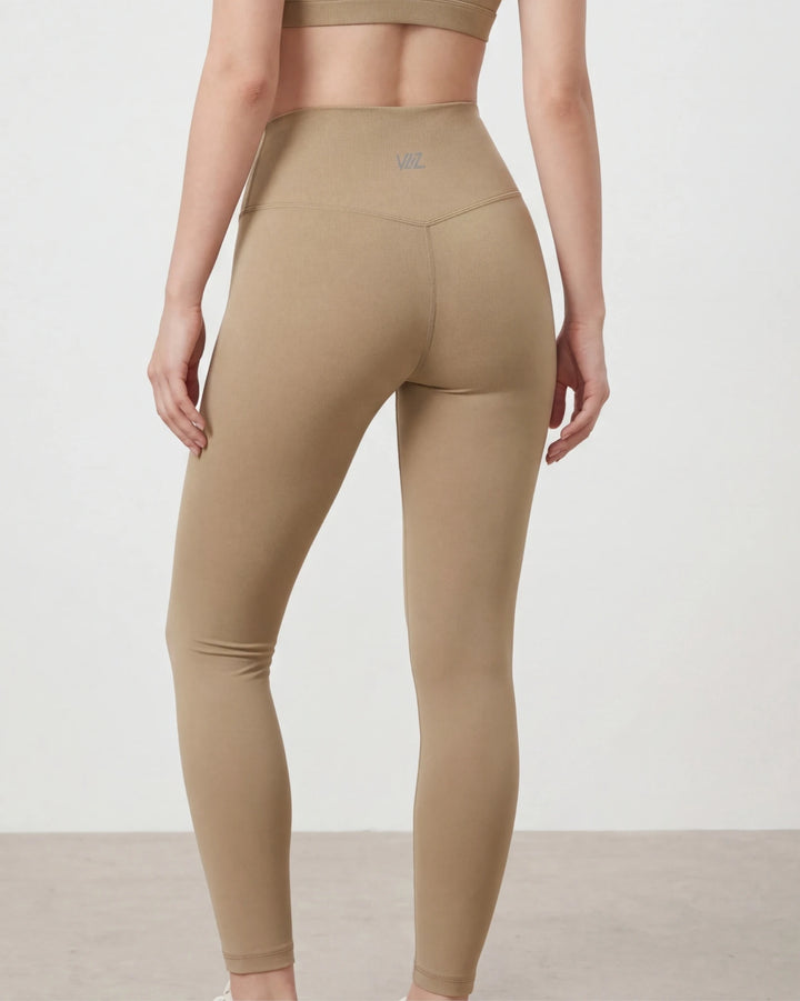 Beige leggings worn by a person on a plain background