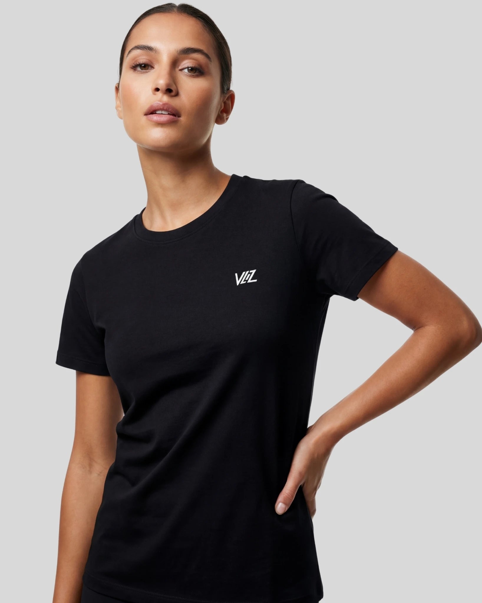 Woman wearing a black t-shirt with a logo on a gray background