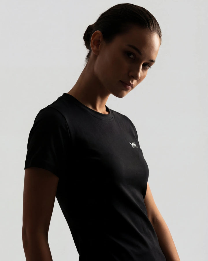Woman wearing a black t-shirt with a logo on a gray background
